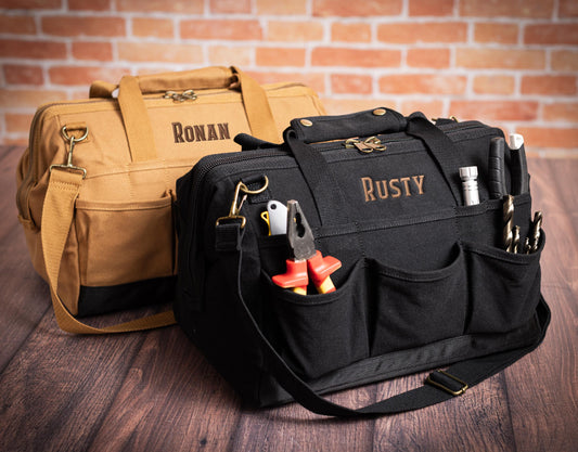 Black canvas tool bag with embroidered initials and exterior organizer pockets.