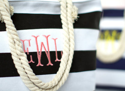 Close-up of the black and white bold stripe tote showing the embroidered script monogram and rope handles