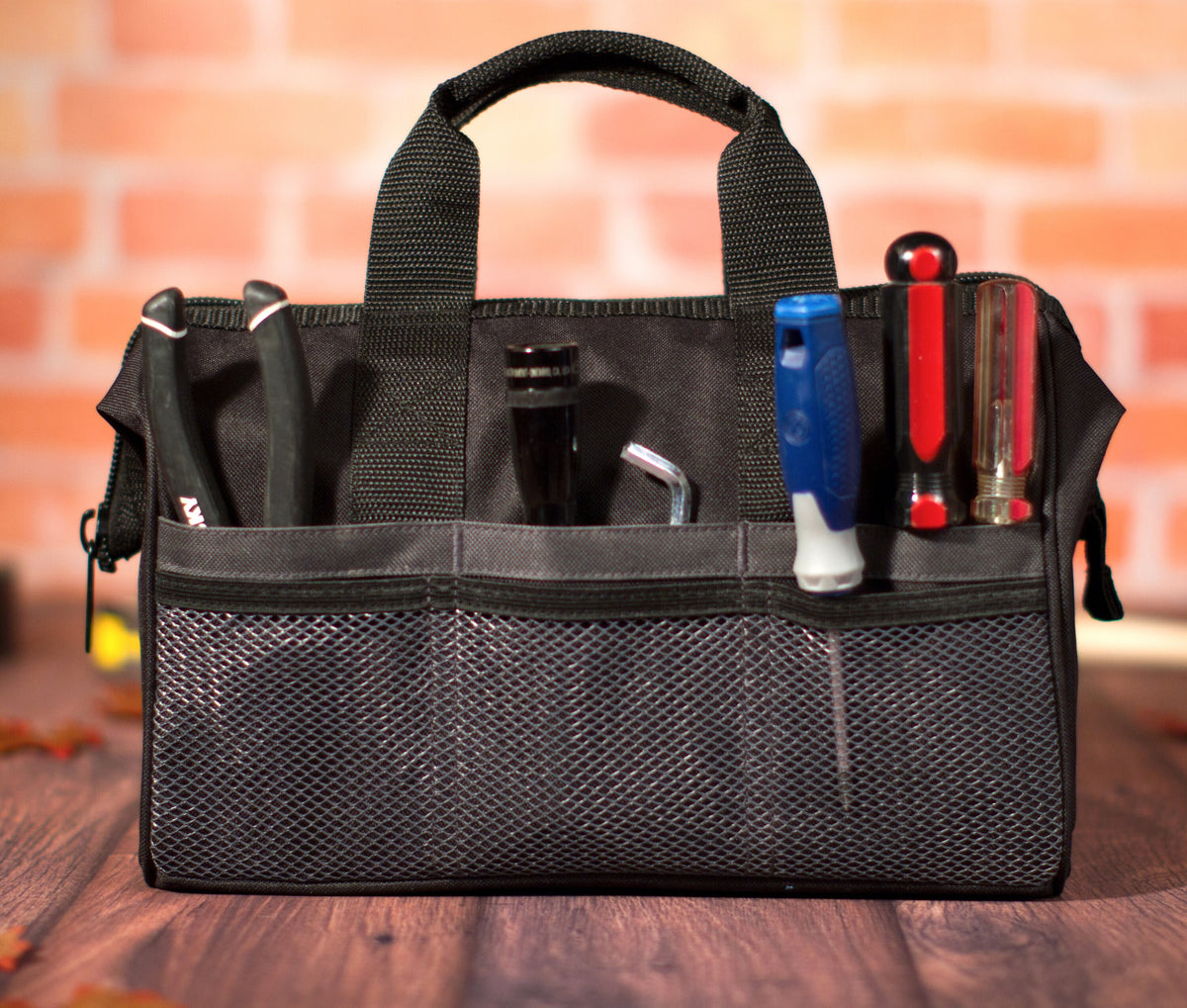 Personalized soft-sided canvas tool bag with hand tools in the exterior pockets and mesh side pocket