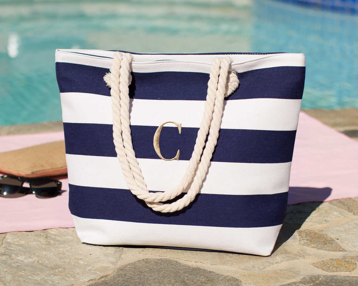 Navy and white bold stripe beach tote standing poolside on a towel