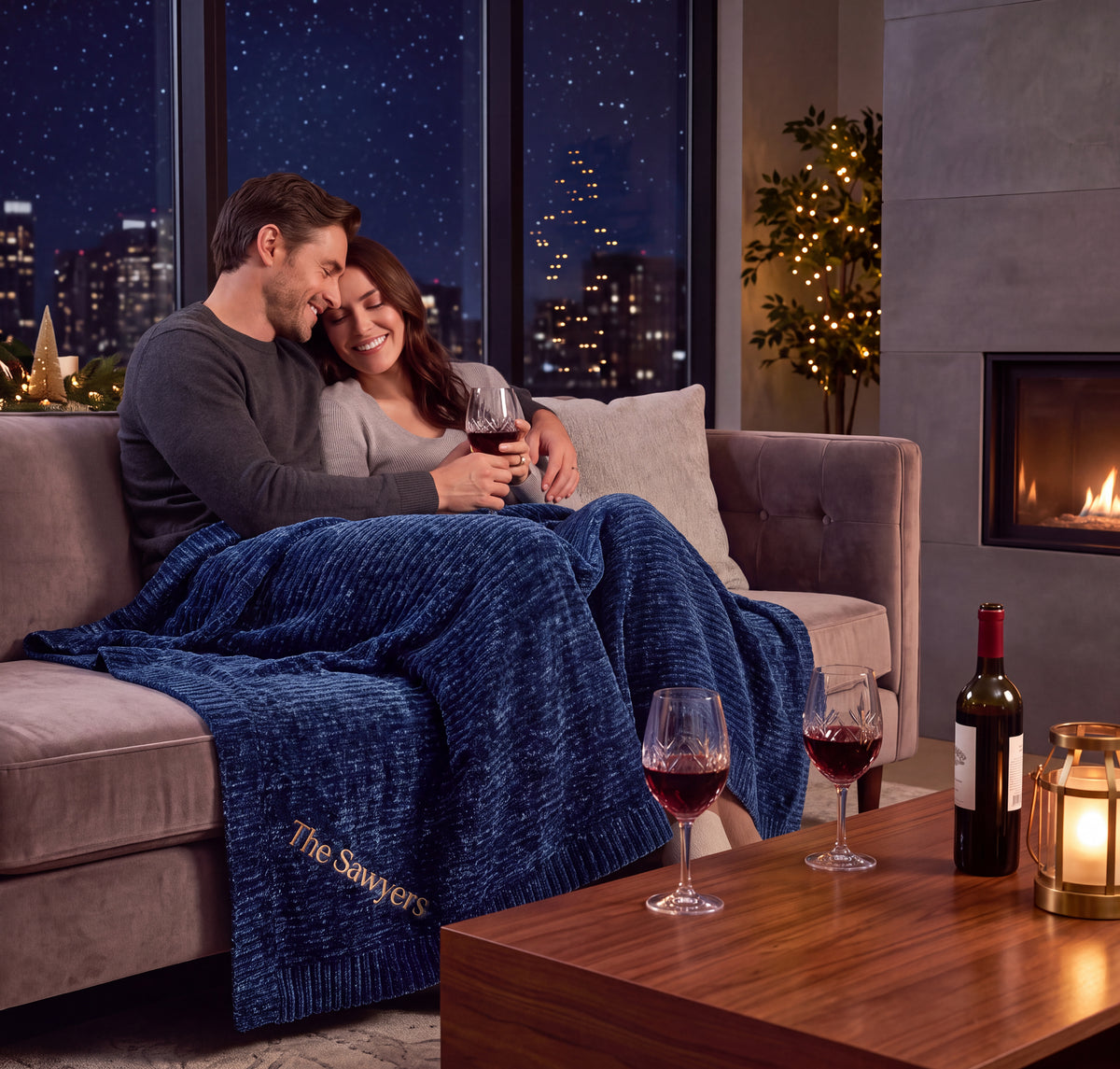 The Stargazer blanket in Nighfall blue. A couple shares a glass of wine and good conversations under the stars set by the soft glow of the city. 