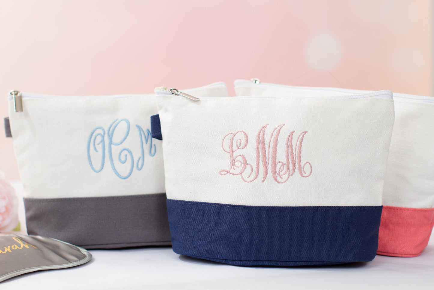The Getaway Canvas Cosmetic Bag — three white canvas cosmetic bags with embroidered initials