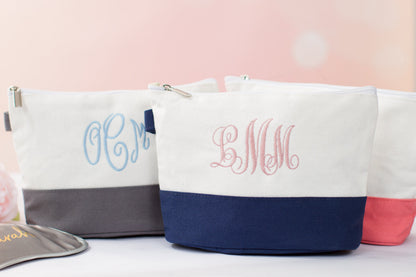 The Getaway Canvas Cosmetic Bag — three white canvas cosmetic bags with embroidered initials