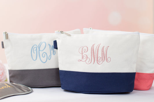 The Getaway Canvas Cosmetic Bag — three white canvas cosmetic bags with embroidered initials