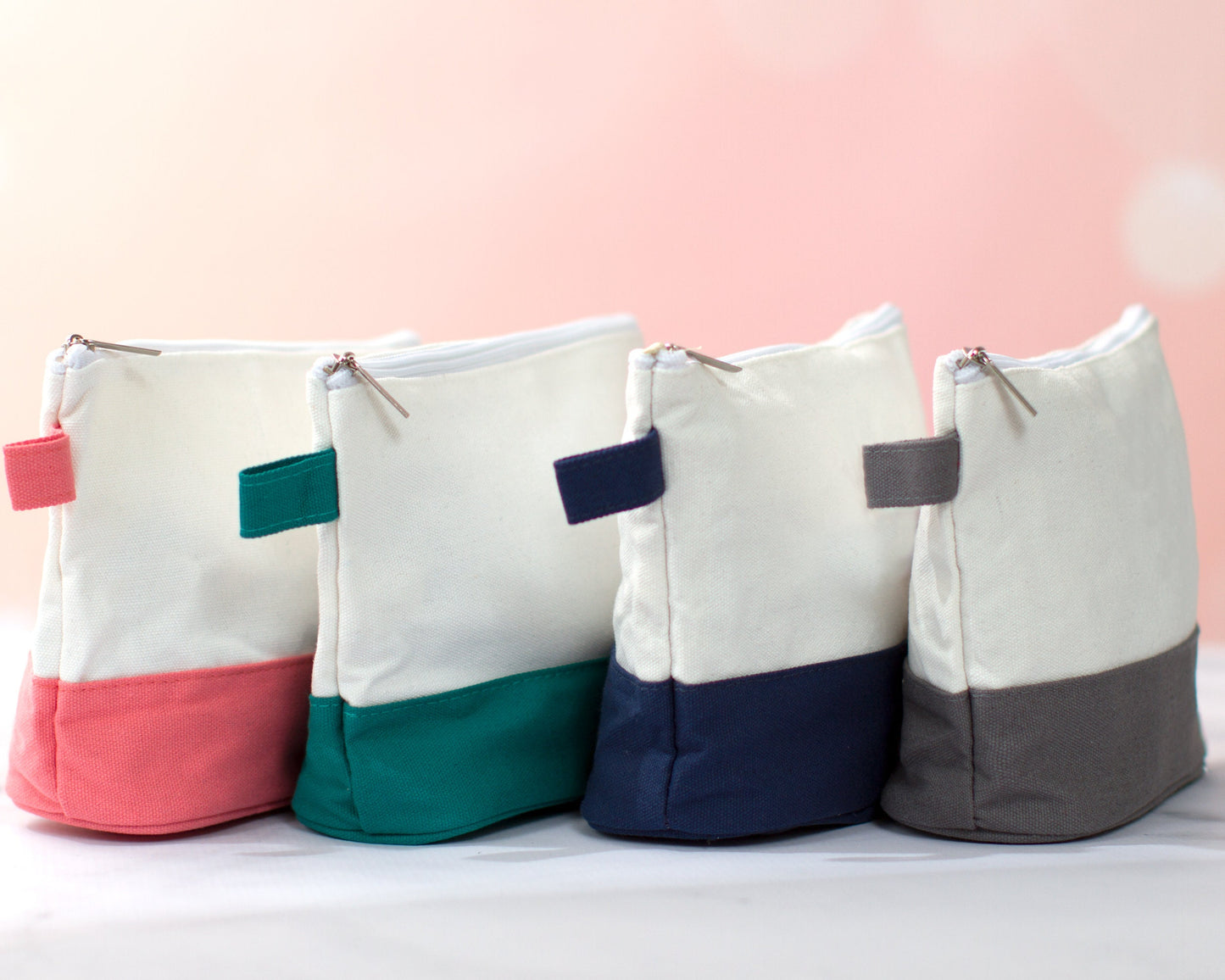 The Getaway Canvas Cosmetic Bag — four bags with colored bottoms