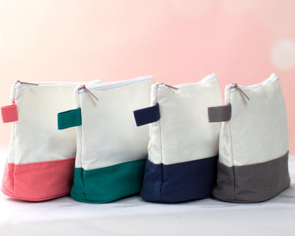 The Getaway Canvas Cosmetic Bag — four bags with colored bottoms