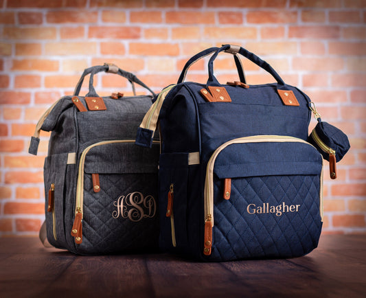 The Nursery Run Diaper Backpack — navy and gray, personalized with a monogram and a family name