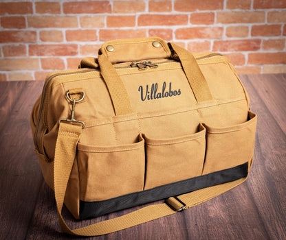 Close view of Brown canvas tool-bag handles, stitching and zipper.